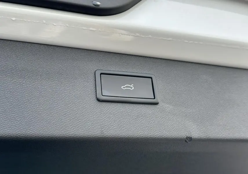 Bouton d'ouverture de coffre sur la garniture intérieure blanche du hayon d'un CUPRA Formentor blanc Neige.