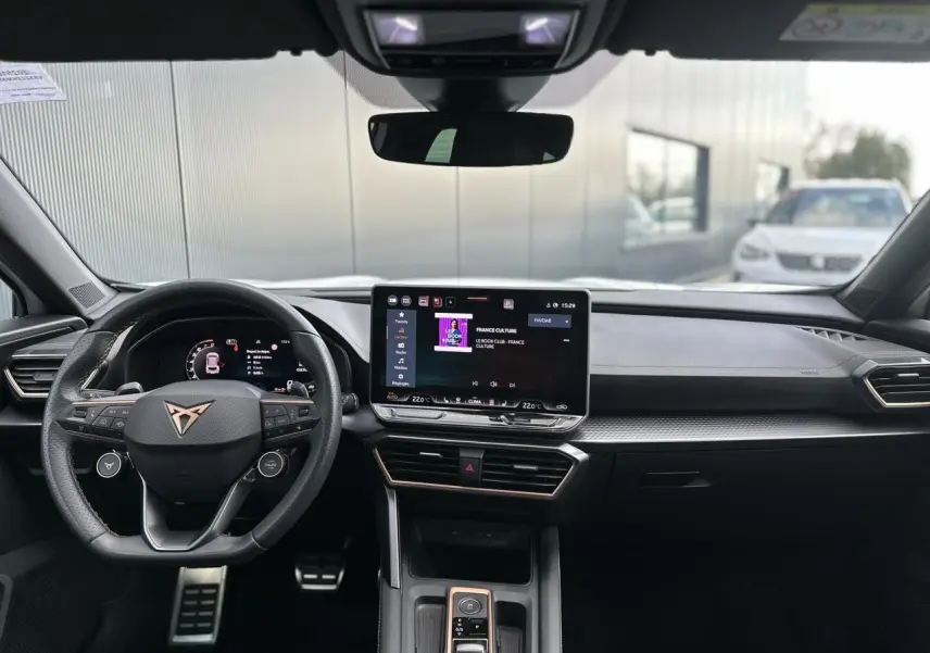 Vue frontale de l'habitacle noir du CUPRA Formentor blanc, avec volant Supersports et écran tactile HD central.