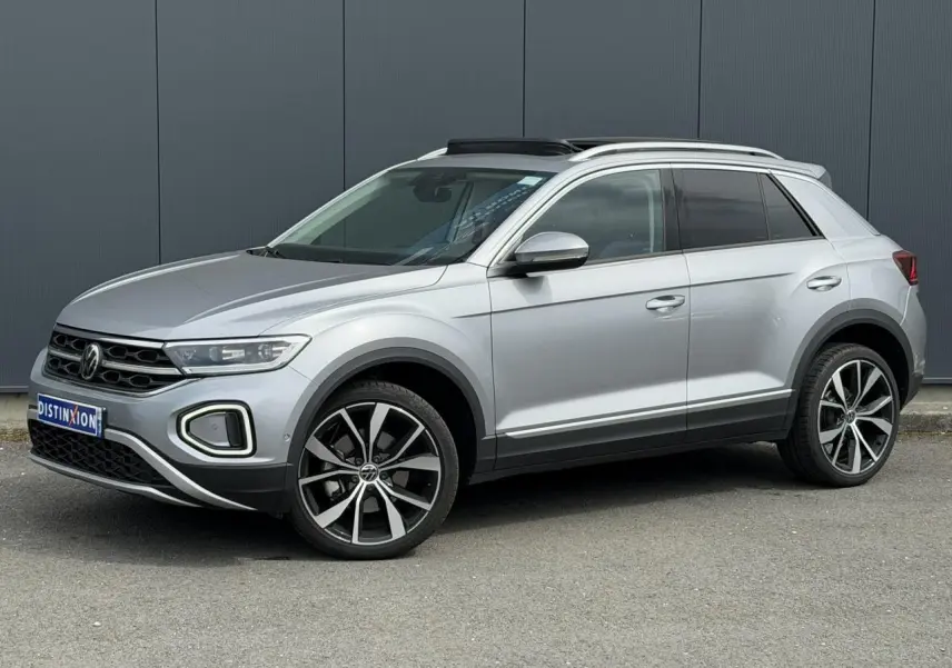Volkswagen T-Roc argent pyrite en 3/4 avant droit, avec jantes alliage 19 pouces et toit ouvrant vitré.