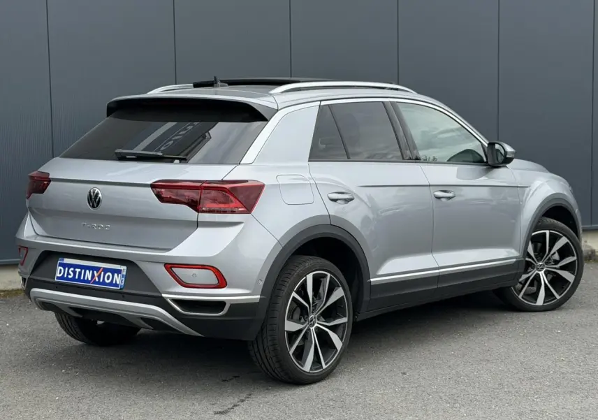 Vue 3/4 arrière droite du Volkswagen T-Roc argent Pyrite avec jantes alliage 19 pouces et vitres arrière surteintées.