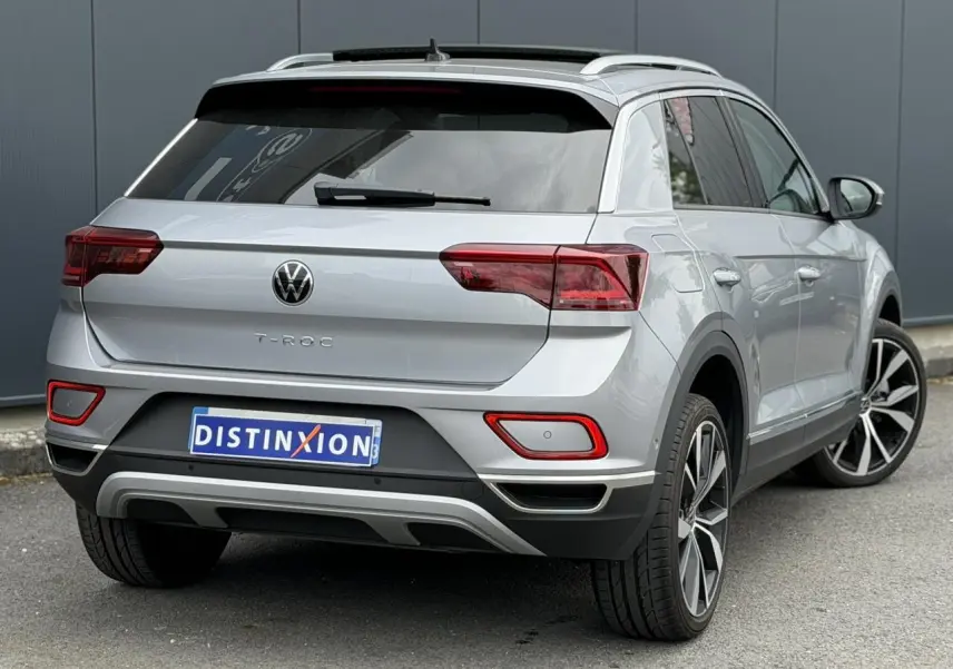 Vue 3/4 arrière droite d’un Volkswagen T-Roc argent pyrite avec jantes alliage 19 pouces et vitres arrière surteintées.