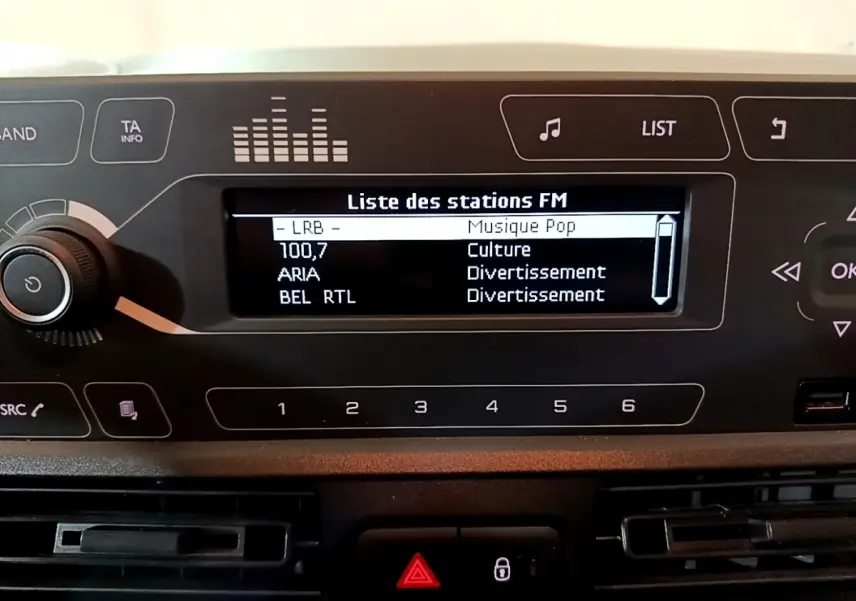Gros plan sur l'écran radio et le tableau de bord noir du Citroën Berlingo blanc, version Club 2021.