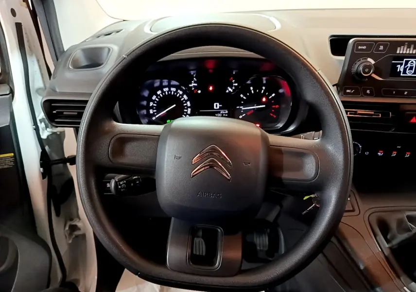 Vue rapprochée du volant noir de la Citroën Berlingo 2021 avec tableau de bord et commandes visibles.
