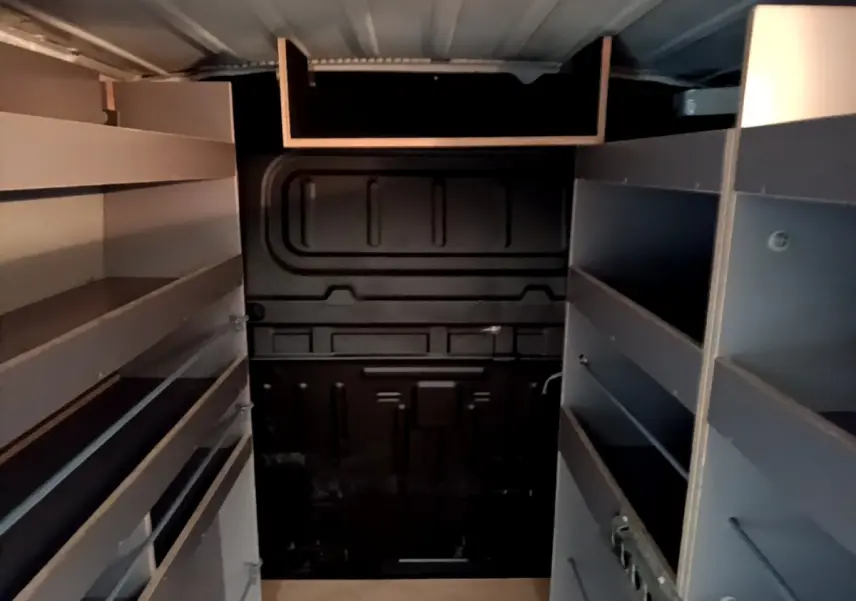 Vue intérieure arrière du Citroën Berlingo blanc 2021 avec cloison pleine et étagères de rangement grises.