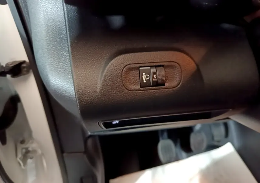 Gros plan sur le réglage manuel des phares dans l'habitacle du Citroën Berlingo blanc 2021 côté conducteur.