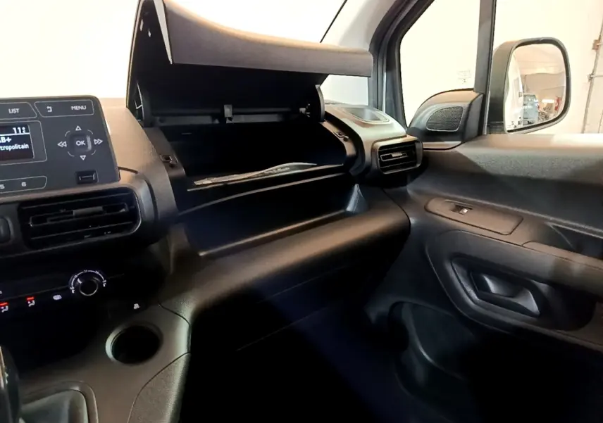 Intérieur du Citroën Berlingo 2021, vue côté passager avec boîte à gants ouverte et tableau de bord noir.