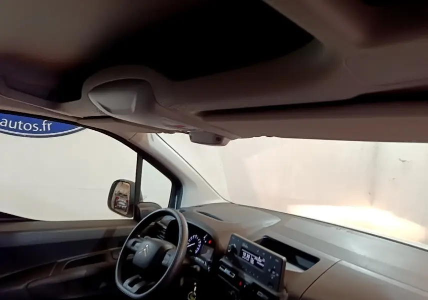 Vue intérieure côté conducteur du tableau de bord et volant du Citroën Berlingo blanc 2021 avec écran tactile central.