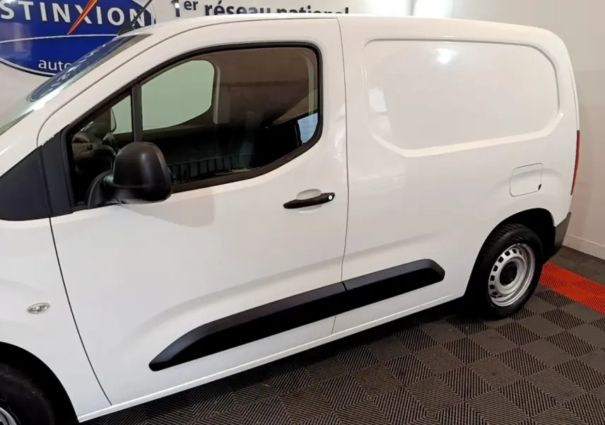 Profil côté gauche d’un utilitaire blanc Citroën Berlingo M 650kg avec poignée noire et jante acier simple.