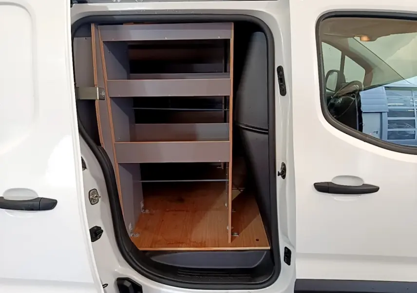 Vue latérale gauche du Citroën Berlingo blanc 2021 avec porte coulissante ouverte montrant les étagères de rangement intérieures.