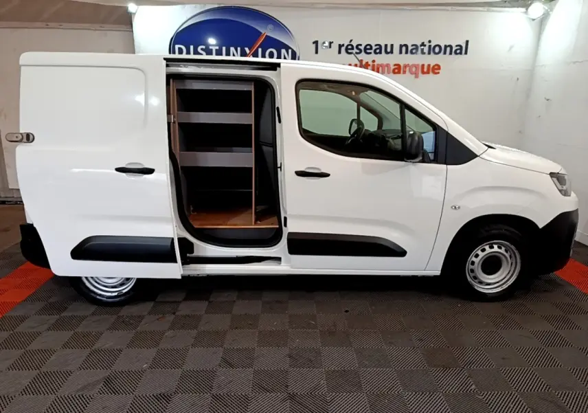 Vue latérale droite d'un Citroën Berlingo blanc 2021 avec porte coulissante ouverte révélant l'intérieur aménagé en étagères.