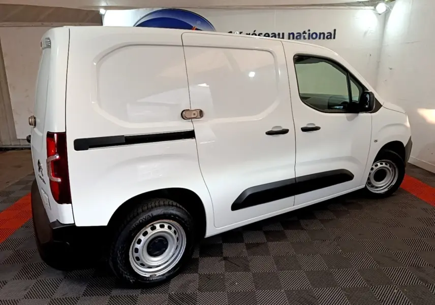 Vue latérale droite d'un utilitaire Citroën Berlingo blanc avec cloison pleine et jantes acier en intérieur.