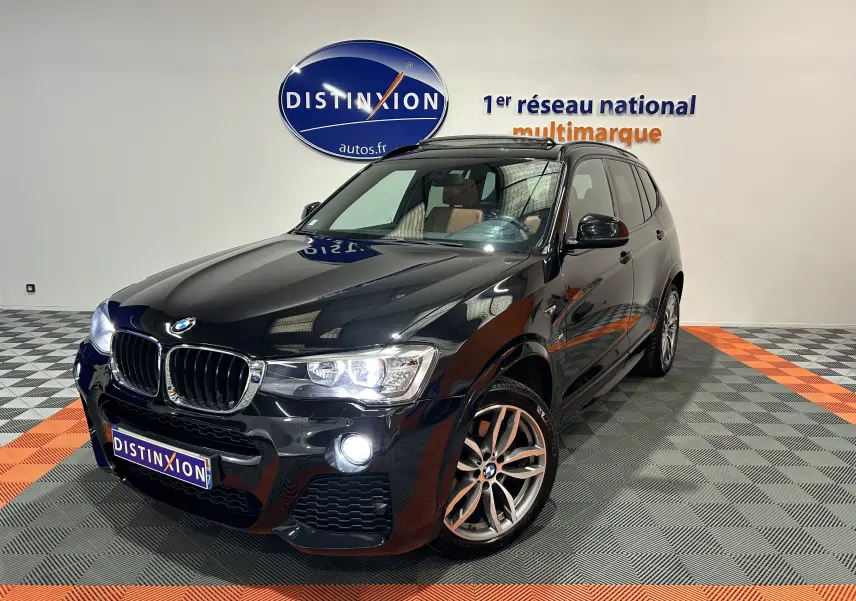 BMW X3 sDrive18d noir en 3/4 avant droit avec toit ouvrant et jantes alliage visibles en intérieur showroom.