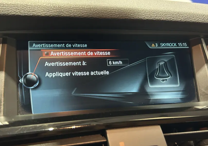 Écran central du BMW X3 noir 2017 affichant le réglage d'avertissement de vitesse à 6 km/h.