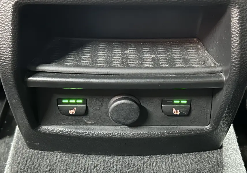 Gros plan sur les commandes des sièges chauffants arrière du BMW X3 noir, avec voyants verts allumés.