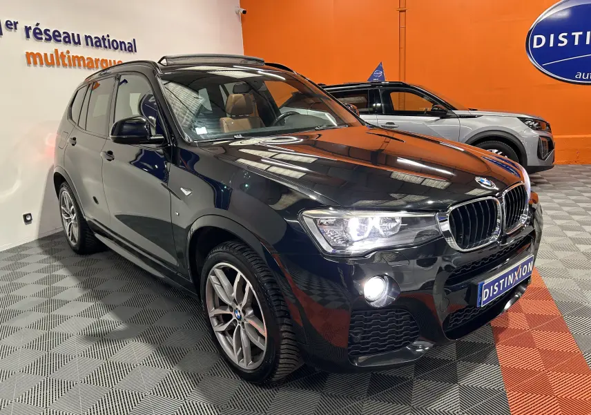 BMW X3 sDrive18d noir vue 3/4 avant avec toit ouvrant et jantes alliage en showroom.
