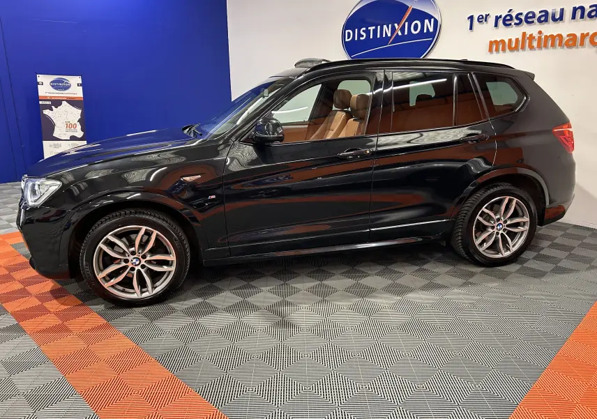 BMW X3 sDrive18d noir en vue profil côté gauche, intérieur cuir marron visible, jantes alliage et toit ouvrant.