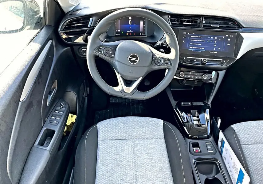 Vue intérieure avant de l’Opel Corsa 1.2 turbo 100 edition bva8, volant multifonction gris, sièges tissu clair et écran tactile.