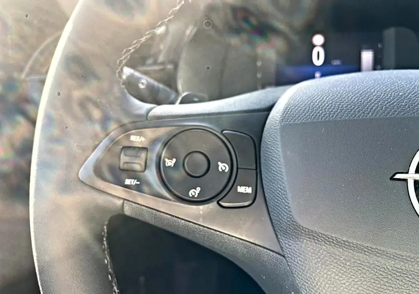 Gros plan sur la partie gauche du volant noir de l’Opel Corsa 2025 avec commandes de régulateur de vitesse.