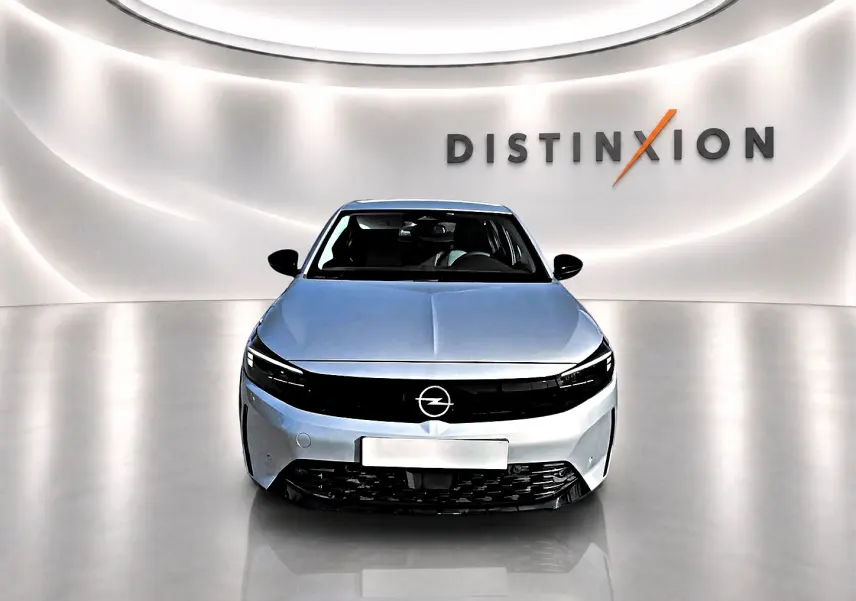 Opel Corsa gris alu vue de face dans un studio lumineux avec logo Distinxion en arrière-plan.