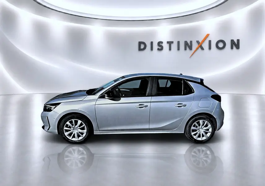 Profil droit d'une Opel Corsa gris alu 2025 avec jantes alliage, sur fond blanc lumineux avec logo Distinxion.