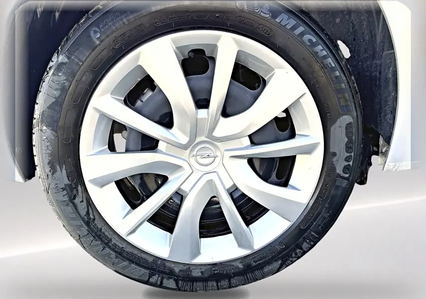 Gros plan sur la roue avant droite d'une Opel Corsa gris alu avec enjoliveur argenté et pneu Michelin.
