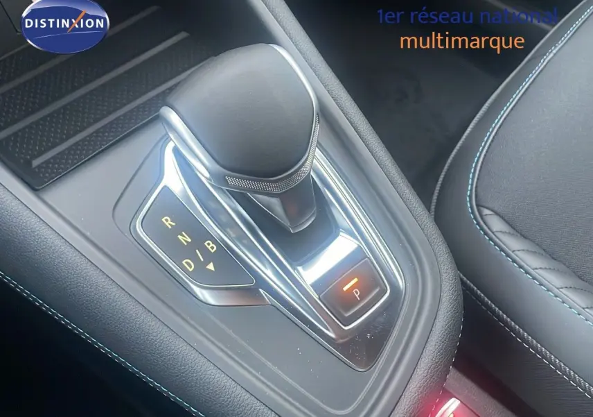 Le levier de vitesse automatique noir et chrome du Renault Captur E-Tech hybride, avec surpiqûres bleues visibles sur l'assise.
