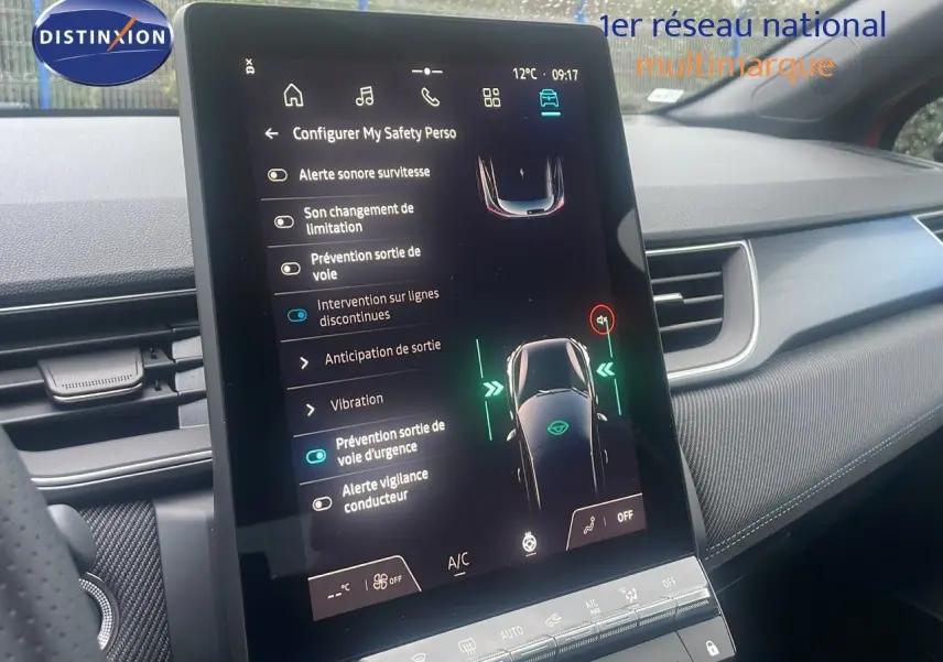 Vue rapprochée de l’écran tactile central du Renault Captur E-Tech rouge, affichant les aides à la conduite.