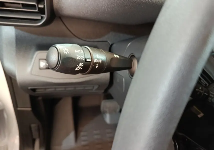 Gros plan sur la commande des phares à gauche du volant du Peugeot Partner XL blanc 2025 Diesel.