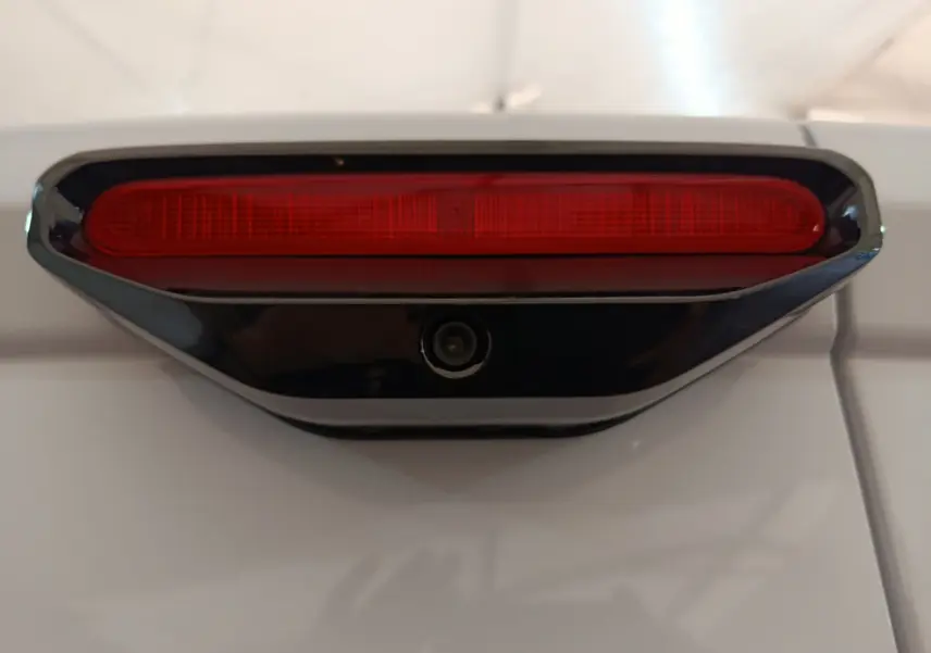 Gros plan sur le feu stop rouge et la caméra de recul intégrée sur la porte arrière blanche du Peugeot Partner XL 2025.