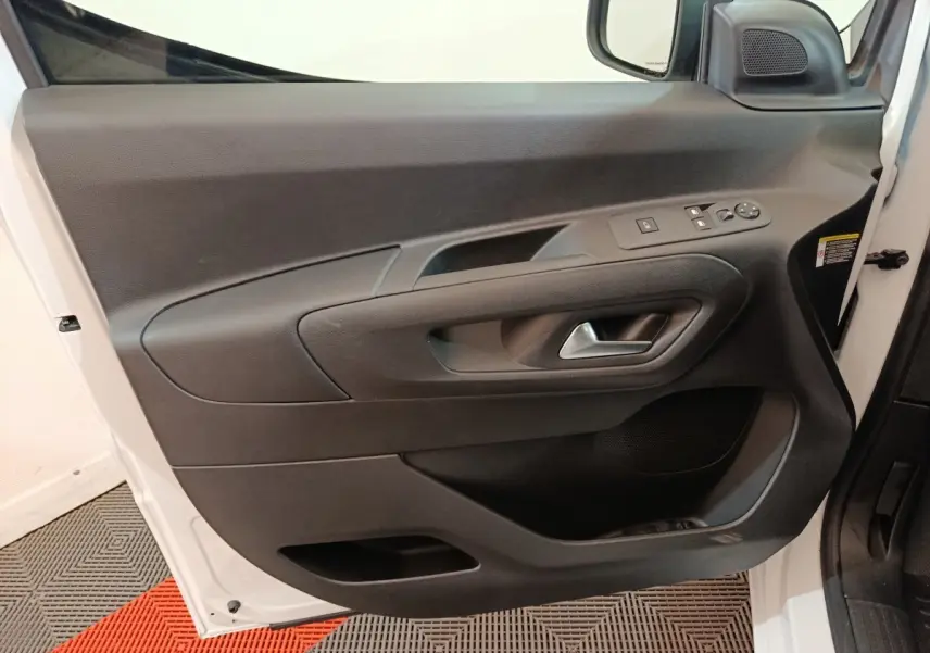 Porte côté conducteur ouverte du Peugeot Partner XL blanc 2025, montrant la garniture intérieure noire avec commandes électriques.