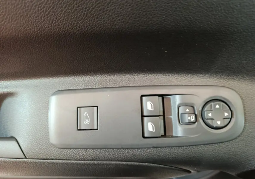 Gros plan sur les commandes de lève-vitres et réglage des rétroviseurs côté conducteur du Peugeot Partner blanc 2025.