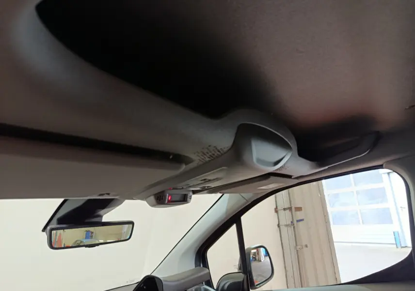 Vue intérieure côté conducteur du Peugeot Partner 2025, montrant le rétroviseur et le plafond avec capteur intégré.