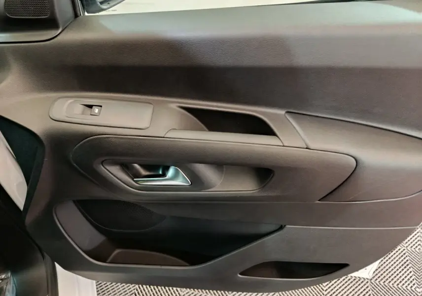 Vue rapprochée de la porte intérieure côté gauche noire du Peugeot Partner XL 2025 avec poignée argentée.