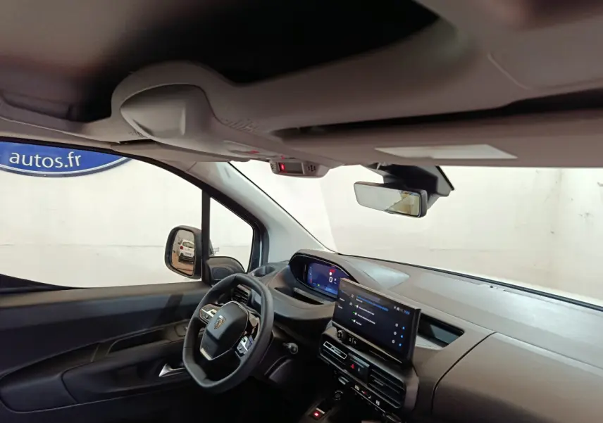 Intérieur du Peugeot Partner XL 2025 vu côté conducteur, tableau de bord moderne avec écran tactile central et volant multifonction.