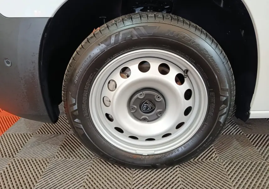 Gros plan sur la roue avant droite en jante acier argentée du Peugeot Partner blanc 2025.