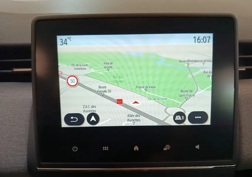 Écran tactile central affichant la navigation GPS dans un Renault Clio gris clair, vue intérieure frontale.