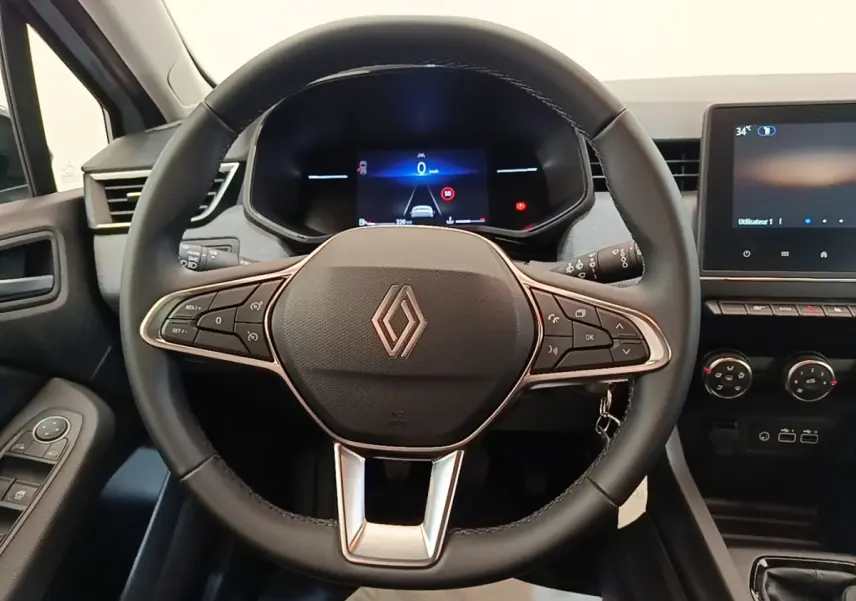 Vue intérieure centrée sur le volant cuir multifonctions et le tableau de bord digital de la Renault Clio gris clair 2025.