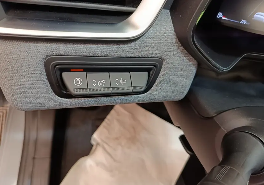 Détail du tableau de bord gris clair de la Renault Clio Evolution dCi 100, avec commandes d'éclairage et verrouillage.