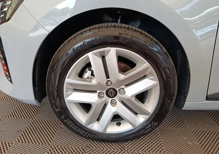 Gros plan sur la roue avant droite grise de la Renault Clio 2025 avec jante alliage et logo Renault central.
