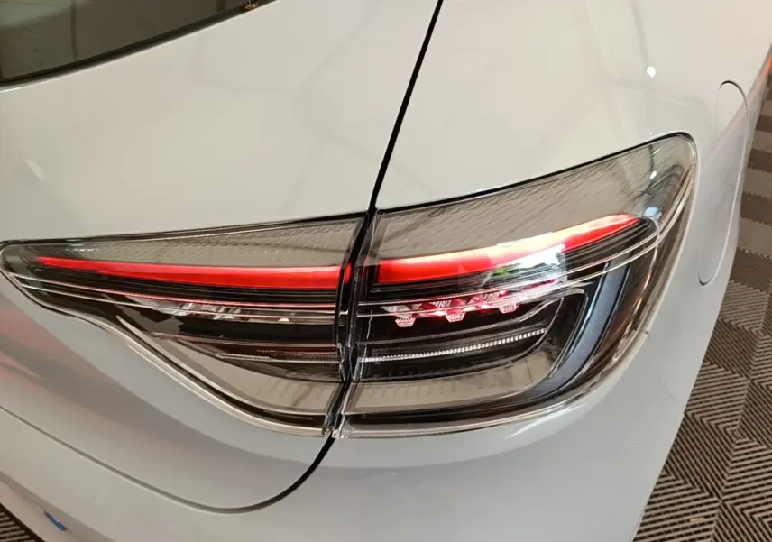 Gros plan sur le feu arrière droit rouge et noir d’une Renault Clio gris clair, version Evolution dCi 100 -25, 2025.