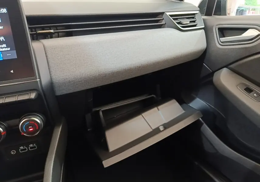 Intérieur de la Renault Clio Evolution dCi 100 2025, vue côté passager sur la boîte à gants ouverte et tableau de bord gris clair.