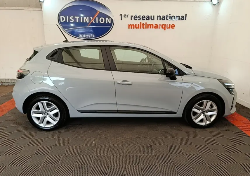 Profil côté droit de la Renault Clio Evolution dCi 100 gris clair 2025, avec jantes alliage et toit avec spoiler.