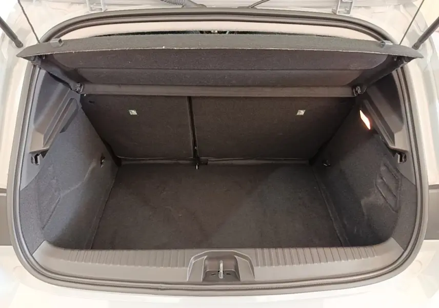 Coffre ouvert vu de l'arrière d'une Renault Clio gris clair 2025, montrant l'espace de chargement vide et la tablette arrière.