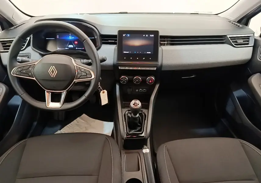 Vue intérieure avant de la Renault Clio 2025 avec volant multifonctions cuir synthétique et écran tactile central.