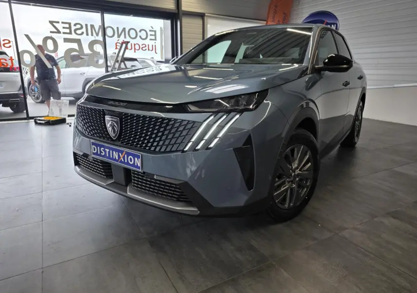 Peugeot 3008 bleu vue 3/4 avant droit en intérieur, avec calandre noire et feux LED à griffes distinctifs.
