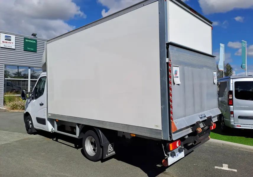 Vue 3/4 arrière droite du Nissan Interstar châssis cabine blanc 2024 avec caisse fermée et hayon élévateur métallique.