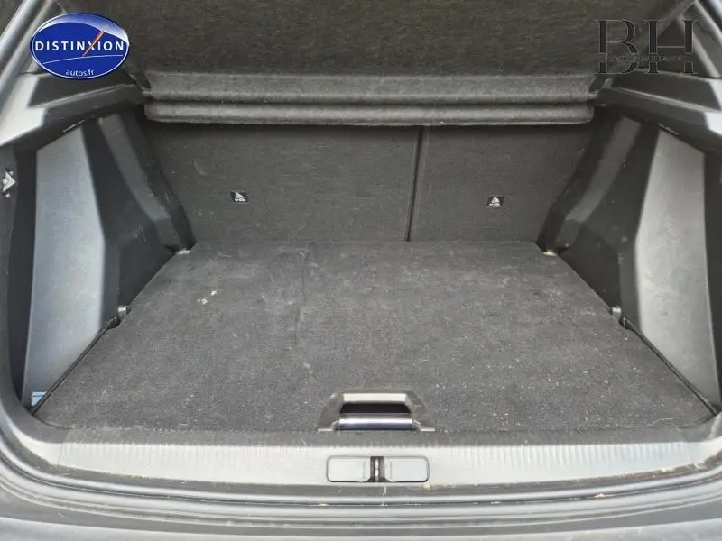 Vue intérieure du coffre noir d'un Peugeot 2008 1.5 BlueHDi 130ch Allure Business EAT8, avec revêtement tissu sombre.