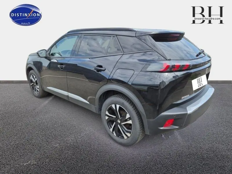 Peugeot 2008 noir Perla Nera vue 3/4 arrière droit, jantes alu, feux arrière LED et barres de toit visibles.