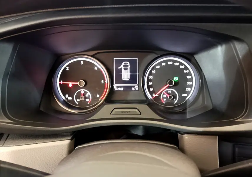 Tableau de bord du Volkswagen Transporter blanc 2021, affichage digital central et compteurs analogiques éclairés.