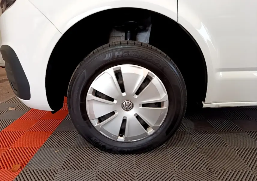 Gros plan sur la roue avant gauche blanche d'un Volkswagen Transporter 2021 avec enjoliveur argenté et pneu Hankook.